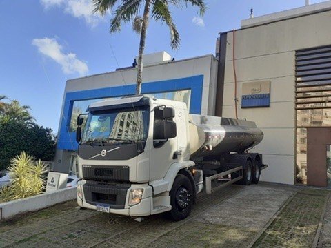 Caminhão metálico Volvo diante de fachada azul e bege. Fotografia do acervo Previni.