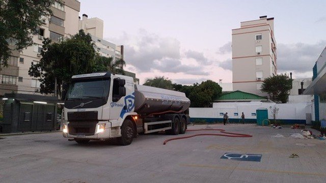 Caminhão Volvo em pátio pavimentado próximo a edifício.