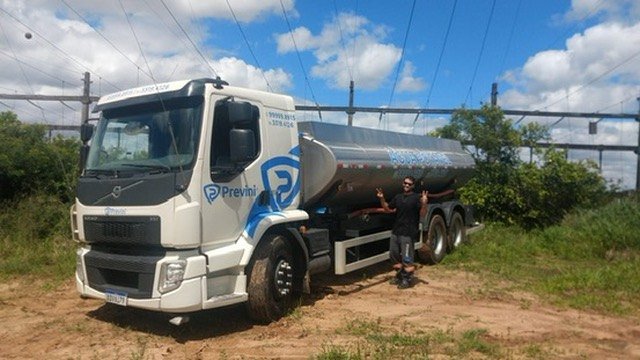 Caminhão de tanque metálico com marca Previni em área gramada. Fotografia do acervo Previni.