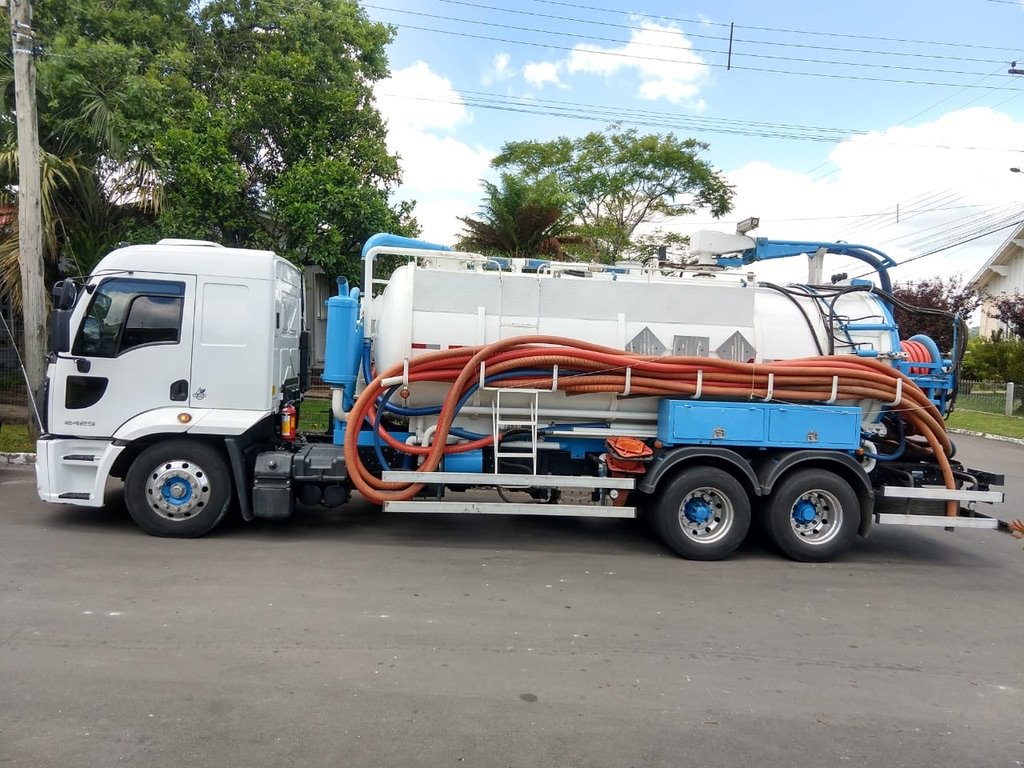 Side view of a service truck with a tank, hose reel and hoses.