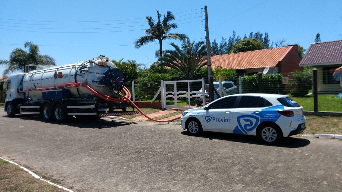 Camión de servicio, vehículo de apoyo y manguera de Previni junto a la entrada de un inmueble.